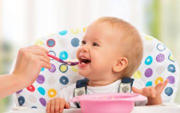 little spoon baby food feeding a smiling baby