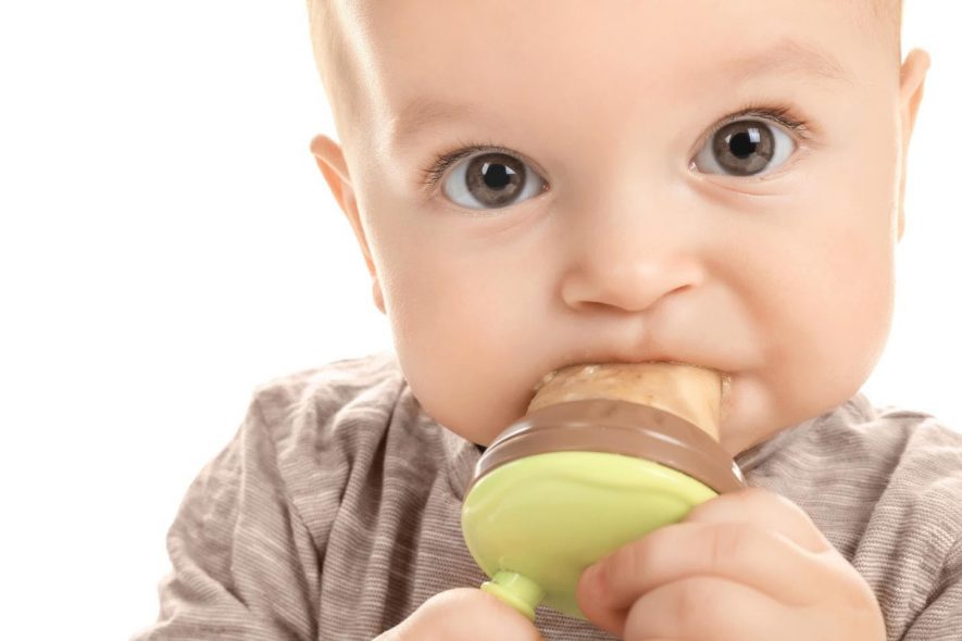 Baby sucking on pacifier teething toy