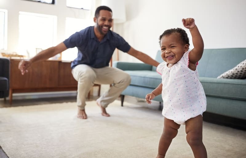 toddler and father dancing at home