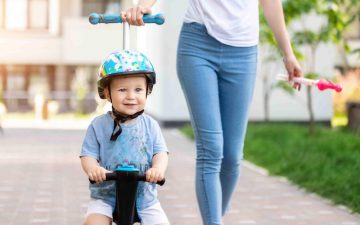 parent pushing toddler on bike with handle